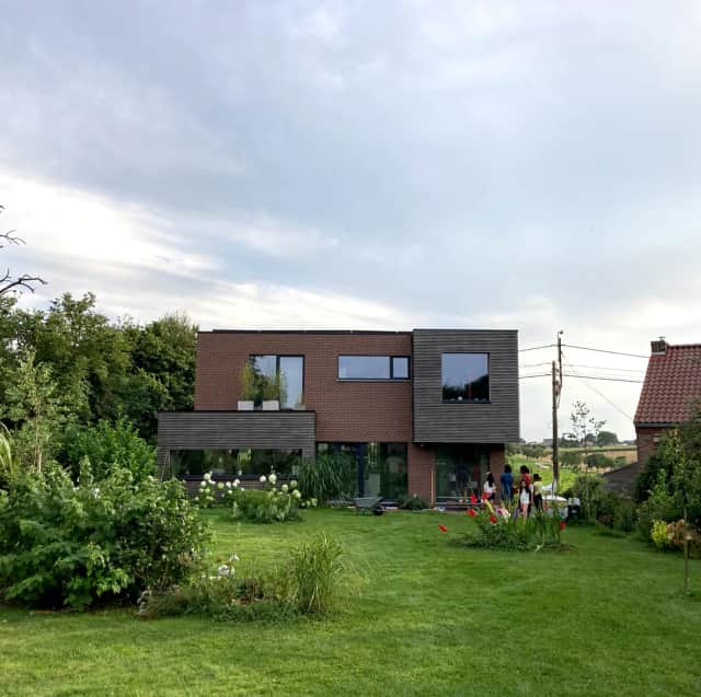 Photo de la façade arrière en brique et afzélia du projet de construction neuve d'une maison unifamiliale à Crisnée par le bureau d'architecture liégeois N8 architecture